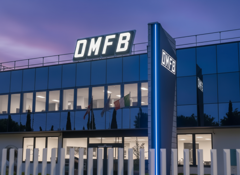 Vista notturna con insegna luminosa bianca a lettere scatolate su tetto del fabbricato e totem bifacciale luminoso nel cortile