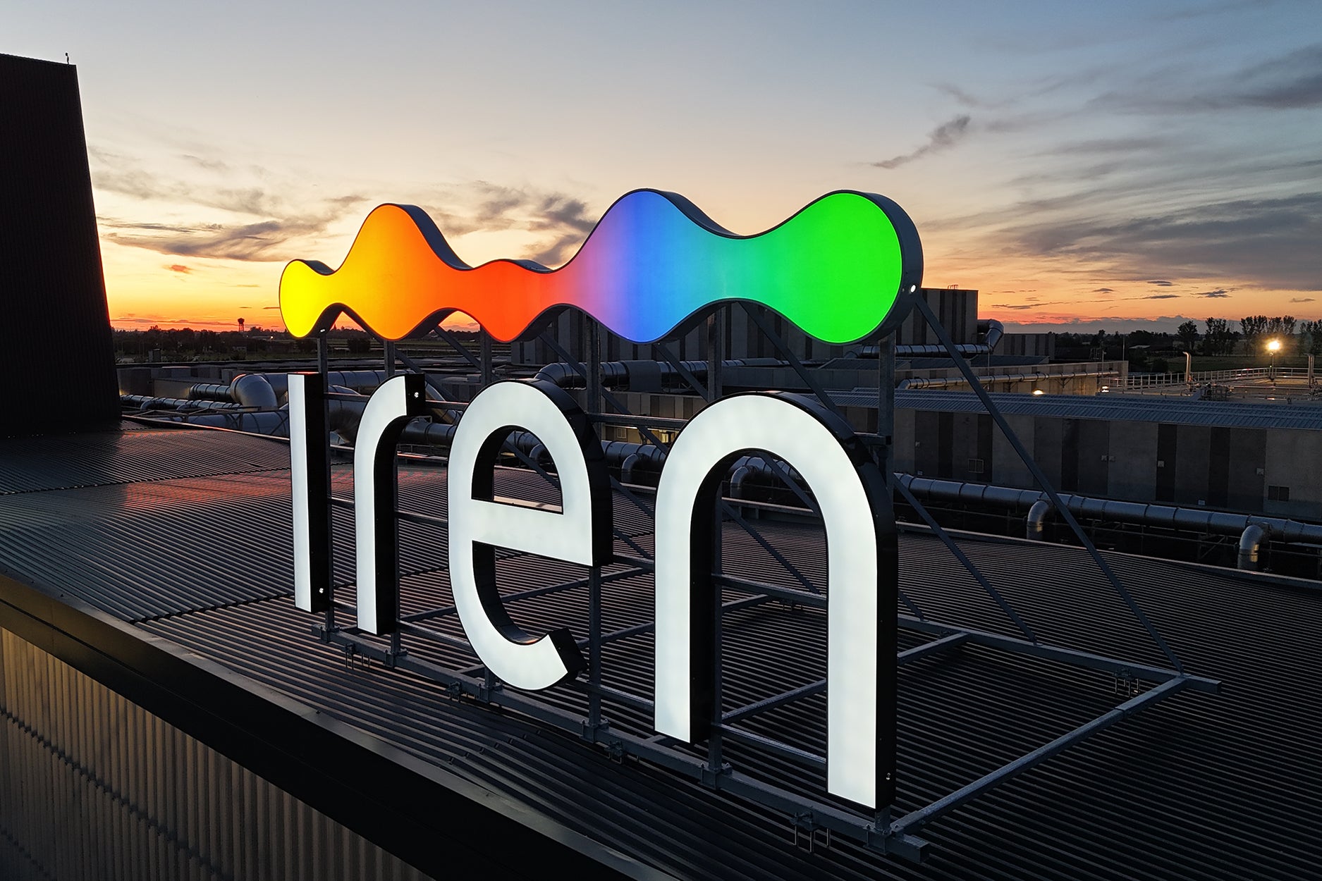 insegna luminosa con lettere bianche e pittogramma arcobaleno su tetto stabilimento Iren Forsu, Reggio Emilia