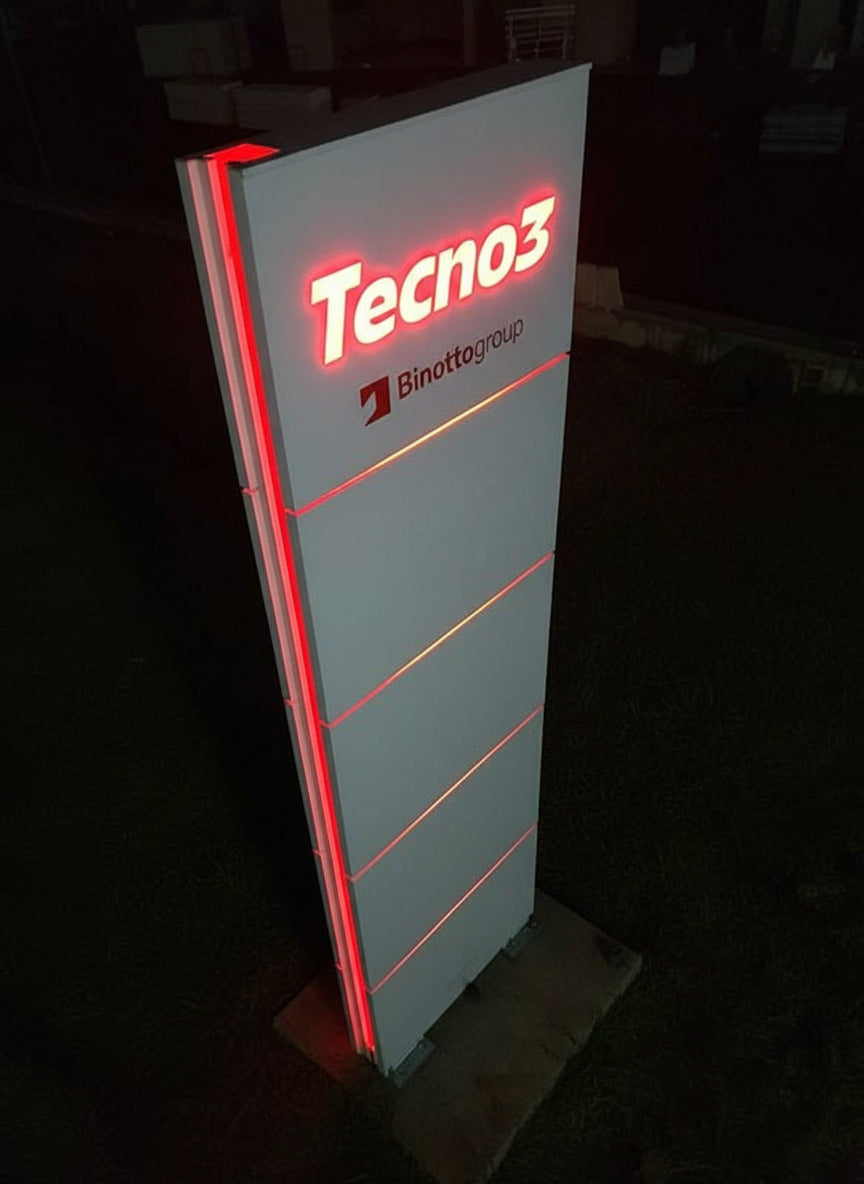 totem esterno per azienda del tipo modulare. Oltre al logo luminoso è presente una gola sul fianco illuminata di rosso